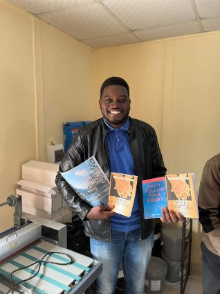 man holds several books